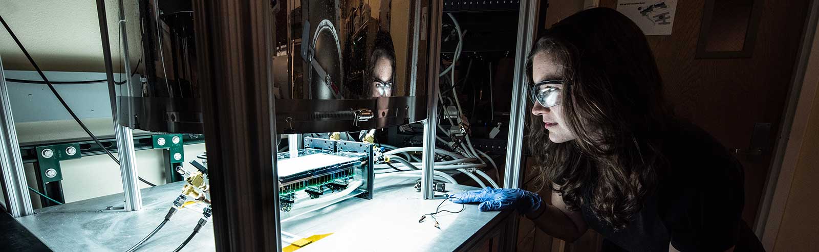 A scientist works with a solar simulator for durability testing of devices.